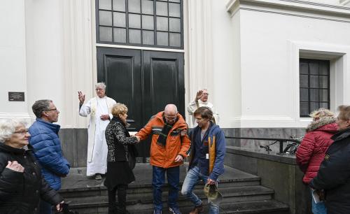 De twee voorgangers spreken hun zegen uit over de parochianen.